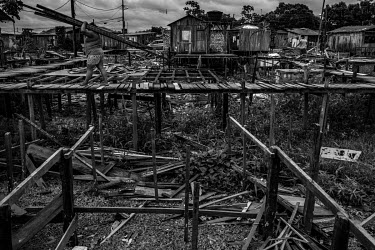 A resident of one of Altamira's stilt houses, who was forced to relocate because of the construction of Belo Monte dam, dismantles a house to reuse the material to build a new home or to expand the fo...