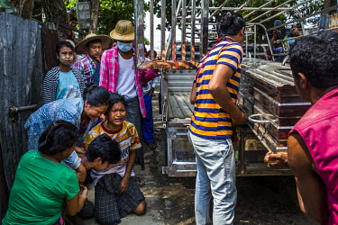 Family members mourn as people take away the dead body of U Win Myint (46) who was shot in the chest when security forces fired live rounds at anti-coup protestors earlier in the morning in the distri...