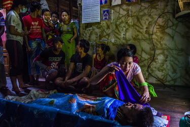 Family member sit beside the dead body of Kyaw Htet Aung (19), a high school student who was shot in the neck, earlier in the morning, by security forces who fired live rounds at anti-coup protestors...