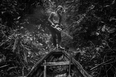 Jasson Oliveira do Nascimento, resident of the Arapixi Extractive Reserve, cuts the vegetation to make way for the canoe in the stream that leads to the Antimary Extractive Settlement Project, where h...