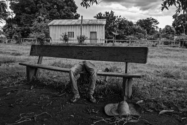 A drunk resident of the Quilombola (Afro-Brazilian) community of Pedras Negras passed out on a bench. The process of providing land deeds to communities started by former slaves was already slow befor...