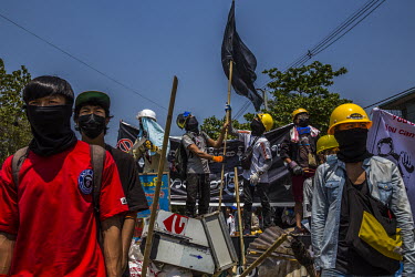 Anti-coup protestors raise a black flag over a barricade erected in Tharketa township ahead of a crack down by the security forces.
