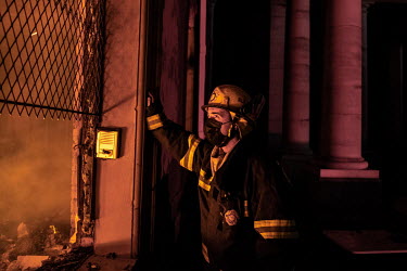 A firefighter looks through a ground floor window of the University of Cape Town's Jagger Library, home to a huge collection of rare and valuable books and documents. Fire gutted the building after a...