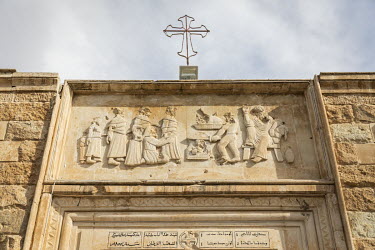 A defaced carving, above the entrance to the Mart Shmouni (Shmoni) Syriac Orthodox Church which was burned and badly damaged by ISIS terrorists during their occupation of Bartella.   Prior to being ov...
