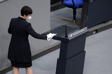 An employee sanitises the lectern during a debate in the German parliament (Deutscher Bundestag).