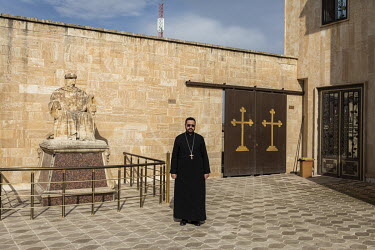 Father Yacoub Saadi in the courtyard of the Mart Shmouni (Shmoni) Syriac Orthodox Church which was burned and badly damaged by ISIS terrorists during their occupation of Bartella.   Prior to being ove...