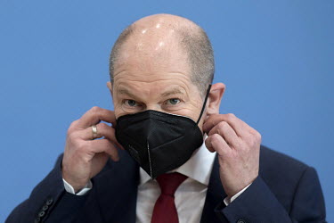 Olaf Scholz, SPD Federal Minister of Finance and Vice Chancellor, puts on a face mask during a press call of the 'Bundespressekonferenz' on the results of the government's Berlin housing policy.