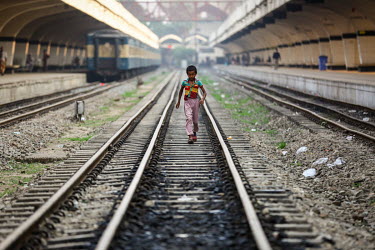 A homeless boy walks along the tracks at at Kamalapur Railway Station (officially known as Dhaka railway station).