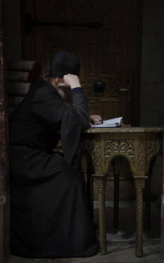 A Greek Orthodox Monk praying inside the Church of the Holy Sepulchre.