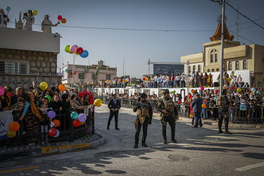 Security personnel standing in street where large crowds of people had gathered to greet Pope Francis on his visit to the mainly Christian town of Qaraqosh.