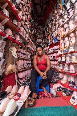 Florzy Anderson sells shoes in a wedge-shaped stall at a busy junction in the middle of Kejetia market (Kumasi Central Market), one of the largest on the continent. The shoes are mostly imported from...