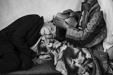 Fareeba, who set herself on fire in 2009, shows her burn scars as her mother brushes her hair at their home in Herat. Forced marriages and a lack of education contribute to a recent spate of suicide a...