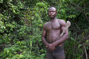 Aboudou Wassiou Dramane (23) clearing land for crops on the edge of a sacred forest in Kikele. The forest is home to approximately 30 white-thighed colobus monkeys (Colobus vellerosus), one of the las...
