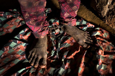 A patient whose has had his ankles shackled sits in a small dark cell at the Emmanuel Rehabilitation Centre for Mentally Ill People which is run by Miss Mojisola Adeniyi. They treat patients with inje...