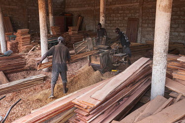Boards being trimmed at a workshop belonging to Ali 'Baba' Biao. Biao says he purchases wood only from permitted sources. Nonetheless government-approved timber forests are often planted at the expens...