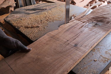 A board being trimmed at a workshop belonging to Ali 'Baba' Biao. Biao says he purchases wood only from permitted sources. Nonetheless government-approved timber forests are often planted at the expen...