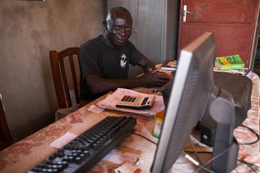 Ali 'Baba' Biao in his office at his carpentry business. Biao says he purchases wood only from permitted sources. Nonetheless government-approved timber forests are often planted at the expense of nat...