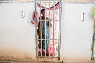 A patient looks out through the bars of her cell in the psychiatric section of Edumfa Heavenly Ministry Spiritual Revival and Healing Centre is split into wards for men and wards for women. The chains...