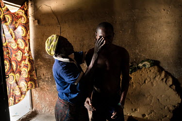 Joshua Aliyu (25) with his mother Laraba Alhaji. Joshua says his illness started six years ago with difficulty moving his hand. Stiffness and pain spread through his body. He also started to struggle...