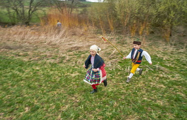 A boy from the Chod folklore group, chasing a girl with a willow whip in an Easter Monday tradition, with pagan origins, when boys whip girls supposedly for good health, luck and fertility.
