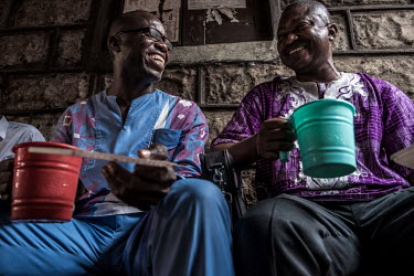 Drinkers enjoy cups of palm wine, or 'poyo', at a speakeasy in central Freetown.