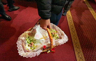 A woman carries an Easter basket containing Easter bread (Paskha), painted eggs and sausages that were blessed by Orthodox priest Jan Polansky during Orthodox Easter.
