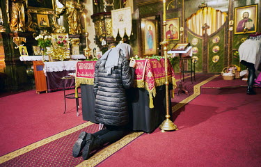An Orthodox devotee praying on her knees before a picture of Jesus Christ on a Holy Shroud in St. Ann's Church.