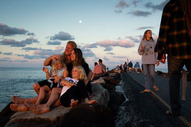 A family, Marty, Gabrielle, Stella and Erica (order of age) from Mullumbimby watch the sunset together on the Brunswick Heads break wall.   The Byron Bay community is at war with a proposed Netflix re...