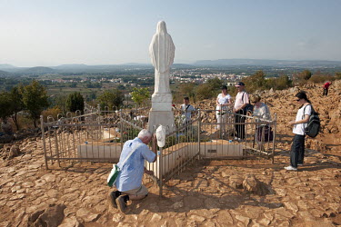 Pilgrims praying on Apparition Hill, a popular site of religious pilgrimage since 1981 when it was reported that apparitions of the Virgin Mary appeared to six local Catholics.
