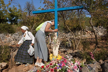 Pilgrims praying on Apparition Hill, a popular site of religious pilgrimage since 1981 when it was reported that apparitions of the Virgin Mary appeared to six local Catholics. The Blue Cross, just be...
