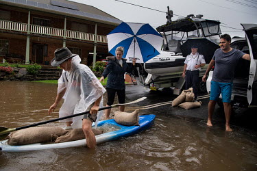 A man collects sand bags using a plastic boat in Windsor where over the previous weekend, the Hawkesbury River rose rapidly by more than 30 feet.