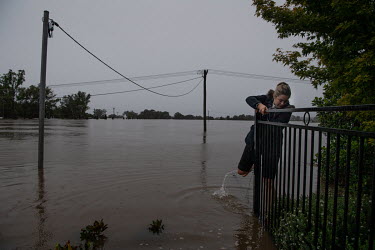 A woman walks through the flood water in Windsor where over the previous weekend, the Hawkesbury River rose rapidly by more than 30 feet.