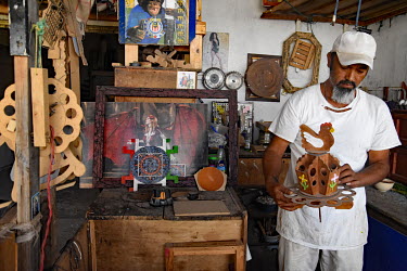 An inmate with a hand made wooden item manufactured in a prison workshop where prisoners make artisanal products for sale.