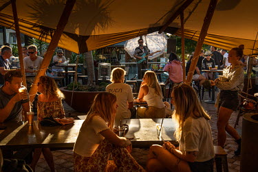 Live music in the beer garden at very busy Byron Bay Beach Hotel.  The Byron Bay community is at war with a proposed Netflix reality TV show called Byron Baes, which locals feel does not represent the...