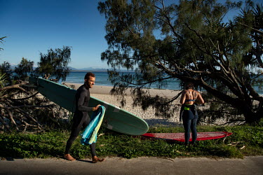 Surfers prepare to enter the water.   The Byron Bay community is at war with a proposed Netflix reality TV show called Byron Baes, which locals feel does not represent their town. A petition calling o...