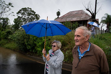 An elderly couple stand in the rain in a partially flooded road. Over the previous weekend, the Hawkesbury River rose rapidly by more than 30 feet.