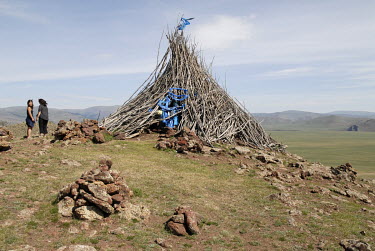 A shamanic 'ovoo' on a hill top near Tariat. An ovoo is a pyramid shaped collection of stones, wood and other offerings, like vodka bottles and silk scarfs, placed on top of a hill or mountain pass as...