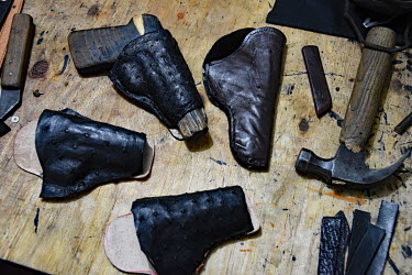 A small leather worker's shop where the owner is making custom holsters for pistols and revolvers.