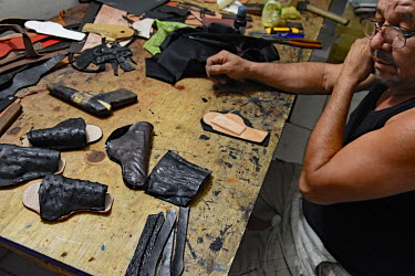 A small leather worker's shop where the owner is making custom holsters for pistols and revolvers.