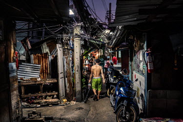 Residents of the sprawling Klong Toei slum community walk through its narrow lanes where social distancing is particularly hard to comply with due to its cramped nature.