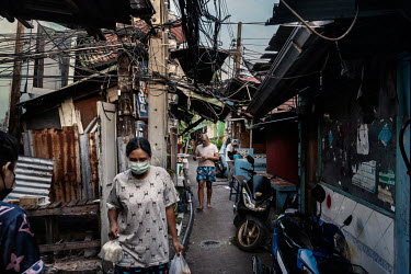 Residents of the sprawling Klong Toei slum community walk through its narrow lanes where social distancing is particularly hard to comply with due to its cramped nature.