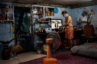 A resident of the sprawling Klong Toei slum community prepares a meal in his cramped home. Social distancing is particularly hard in the poorer slum communities in Bangkok.