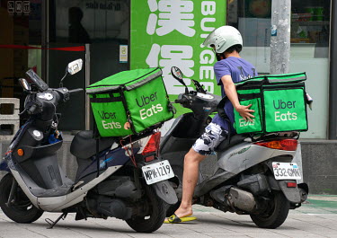 Uber Eats food delivery riders outside a fast food restaurant in central Taipei. Meal delivery services such as Food Panda and Uber Eats have seen a boom in demand ever since Taiwan entered Level 3 (o...