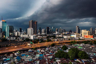 A storm rolls in over the Klong Toei slum district (bottom) where there has been a surge in COVID-19 cases. The high rise condos and offices of Sukhumvit Road commercial district are seen in the backg...