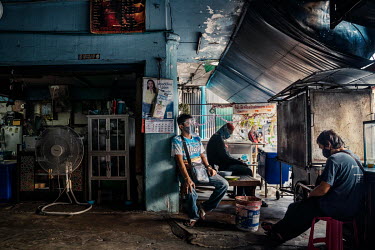 Motorbike taxi drivers wait in a closed restaurant in the Klong Toei community.
