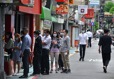 Office workers queue at lunchtime outside a popular restaurant in central Taipei. Such establishments have to sell food to take away due to a ban on indoor dining since Taiwan entered Level 3 (of 4) C...