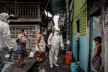 Rescue workers chat with residents as they prepare to spray disinfectant in the homes of people who tested positive for COVID-19, in the Klong Toei slum community.