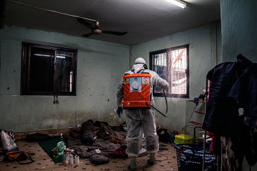 A rescue worker sprays disinfectant in a home of somebody who tested positive for COVID-19, in the Klong Toei slum community.