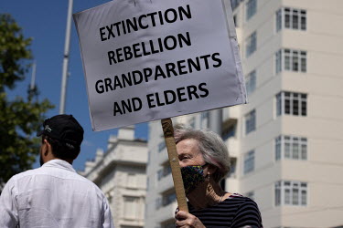 A woman carries an Extinction Rebellion Grandparents and Elders placard during a protest by scientists against Shell's sponsorship of 'Our Future Planet', an exhibition advocating techno-fixes for the...