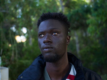 Daouda Faye (25), a migrant from Senegal, who says he lost the sight in his left eye while in Morocco, stands in a small wood in the Spanish exclave of Ceuta.